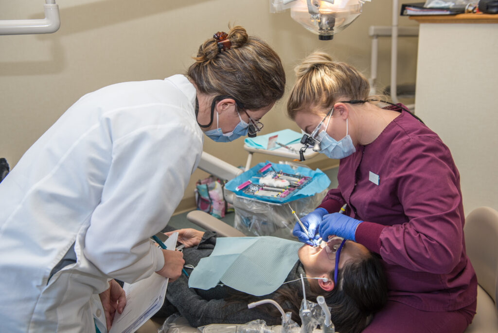 dental hygienist student learns from instructor at NHTI